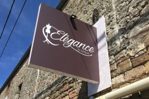Une enseigne drapeau lumineuse réalisée pour Élégance Boutique, intégrant un design raffiné, un éclairage LED efficace et une finition matte.
