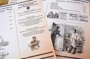 Menu imprimé style journal vintage – Un concept graphique original qui plonge les clients dans une ambiance d’époque avec illustrations gravées et mise en page soignée.