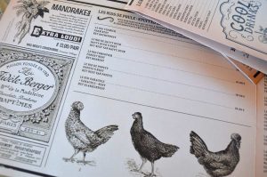 Menu imprimé style journal vintage – Un concept graphique original qui plonge les clients dans une ambiance d’époque avec illustrations gravées et mise en page soignée.